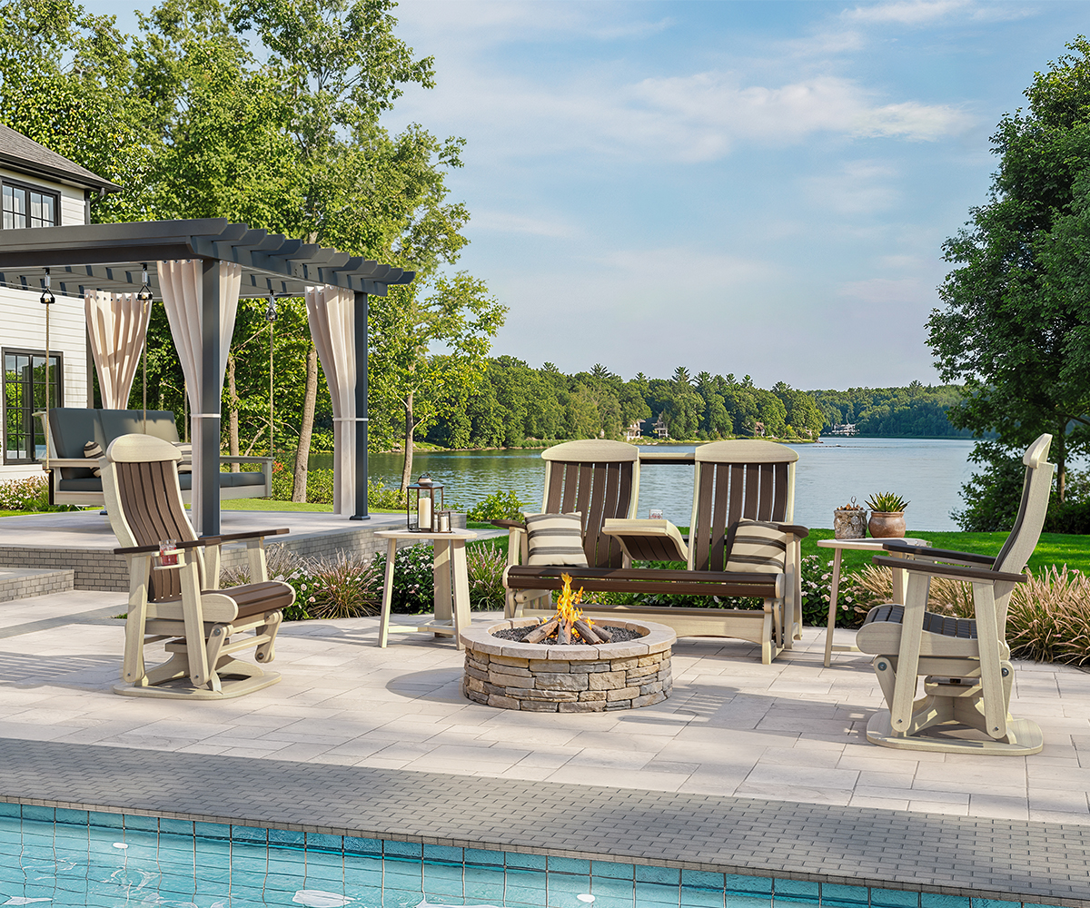 Outdoor poly furniture by fire pit on lakeside patio with gliders.